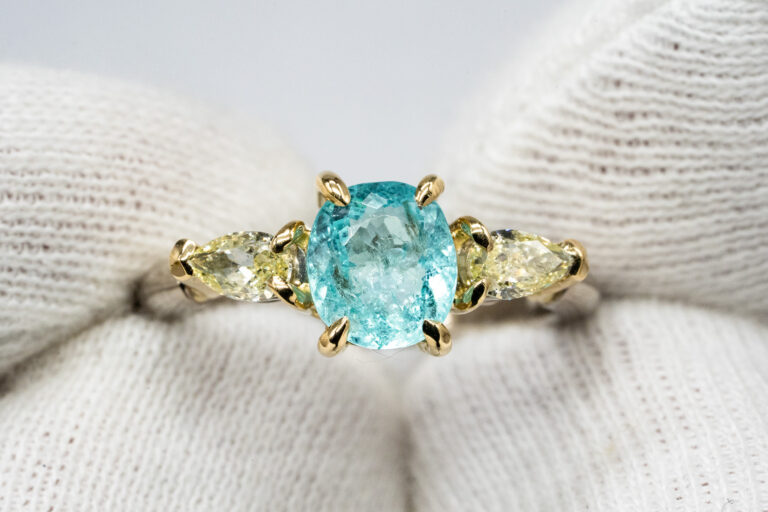 Handgefertigter Ring mit einem Paraiba Turmalin in Weißgold mit einer Fassung aus 750 Gelbgold